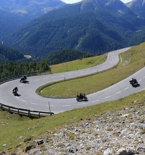 Motorrijders in haarspeldbochten tijdens dag 2 van de motorreis Oostenrijk Italië Slovenië; panoramische Alpenroute met strak asfalt.