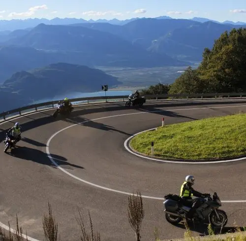 Motorrijders op een bergpas met uitzicht over de Alpen tijdens motorreis Best of the Alps