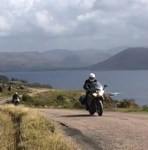 Motor op een landelijke weg langs een Schots loch tijdens motorreis Epic Scotland