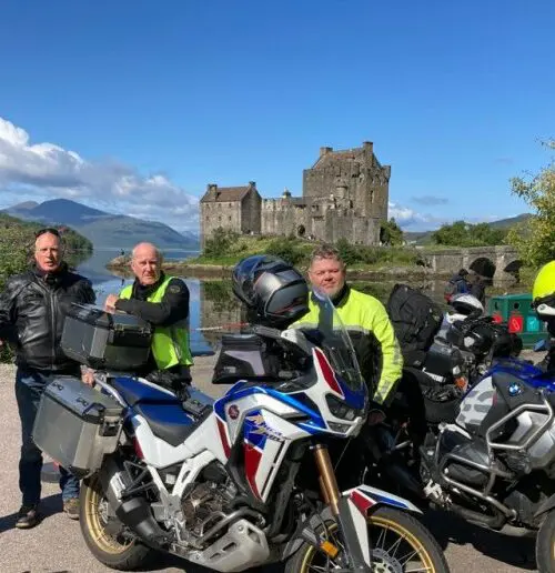 Motorrijders met motoren bij een Schots kasteel tijdens motorreis Epic Scotland