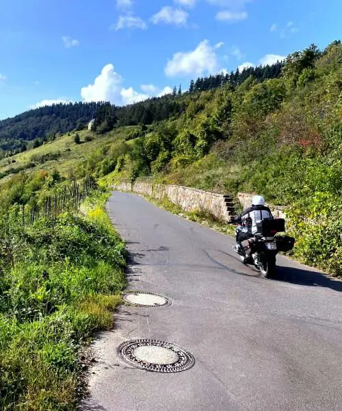 Motorrijder op een landelijke bergweg tijdens motorreis Journey to the Heart of Europe