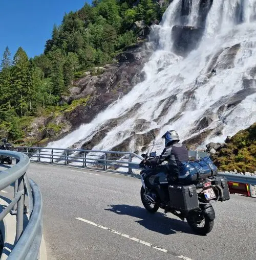 Motorrijder bij waterval tijdens motorreis Norwegian Shortcut, Fjord Norway, Noorwegen