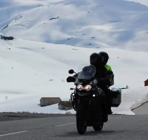 Motorrijder door sneeuwlandschap tijdens motorreis Norwegian Shortcut, Fjord Norway