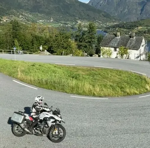 Motor in bergbocht met uitzicht op fjord tijdens motorreis Norwegian Shortcut, Noorwegen