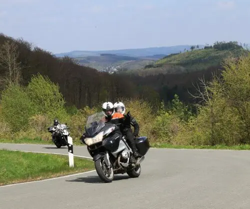 Motorrijders op een bochtige weg door het groene Sauerland – motorreis Sauerland Rothaargebirge
