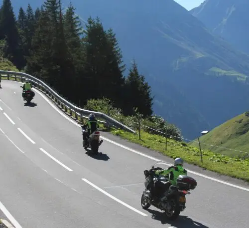 Motorrijders op een bergweg door de Alpen