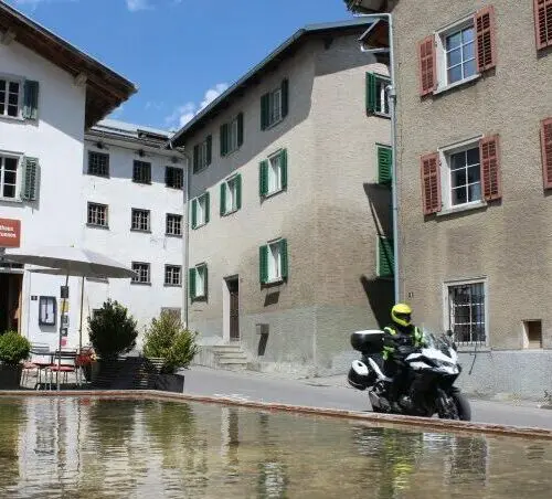 Motorrijder in een historisch bergdorp in de Alpen