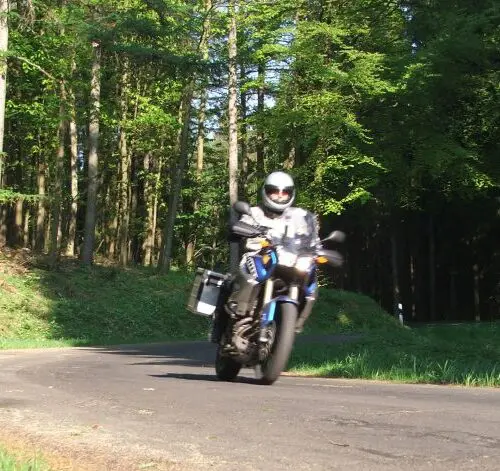 Motorrijder op een bosweg in het Westerwald, Duitsland