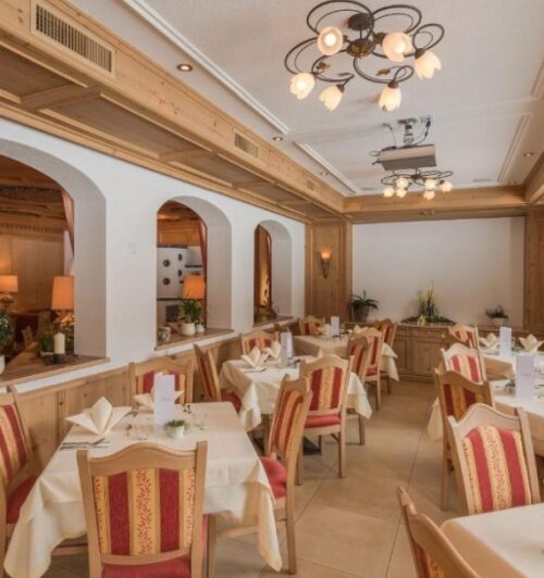 Sfeervol hotelrestaurant met gedekte tafels in de Alpen