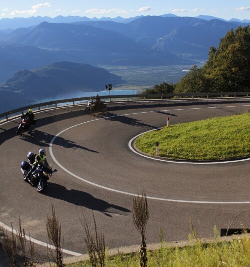 Motorrijders op een bochtige bergweg door de Dolomieten in Zuid-Tirol, Italië